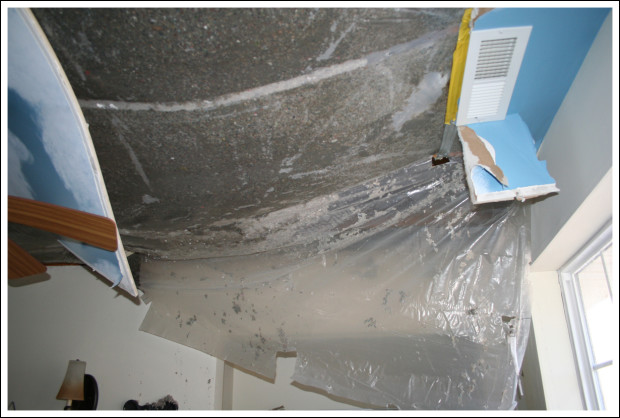 Plastic vapor barrier bulging under wet cellulose insulation.